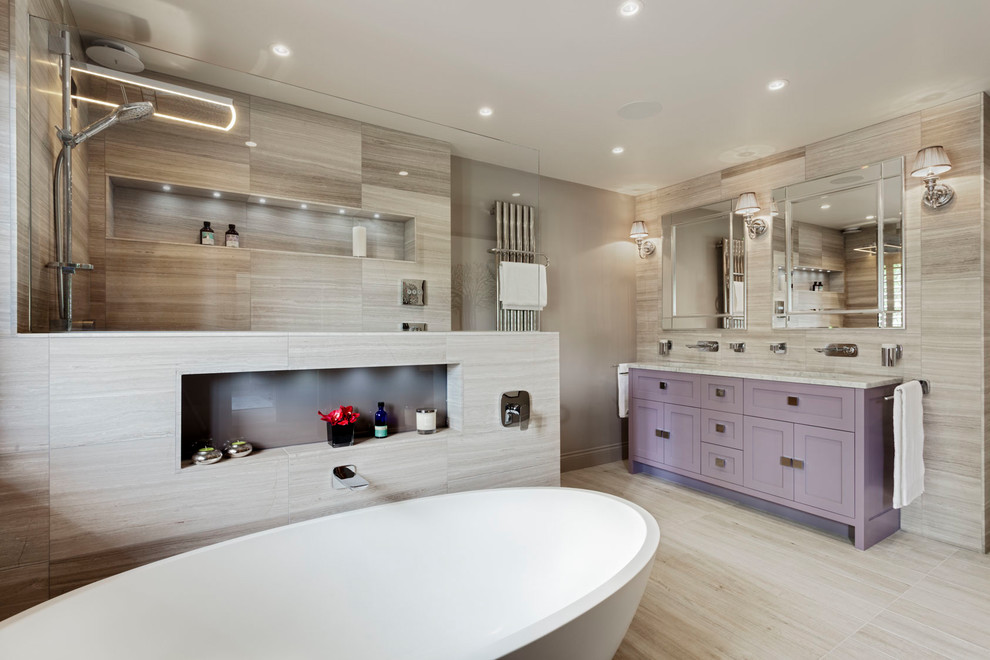 Cette image montre une salle de bain principale traditionnelle de taille moyenne avec un placard à porte shaker, des portes de placard violettes, une baignoire indépendante, un espace douche bain, un carrelage gris, un mur gris, un lavabo encastré, un sol gris, aucune cabine, un plan de toilette gris et une niche.