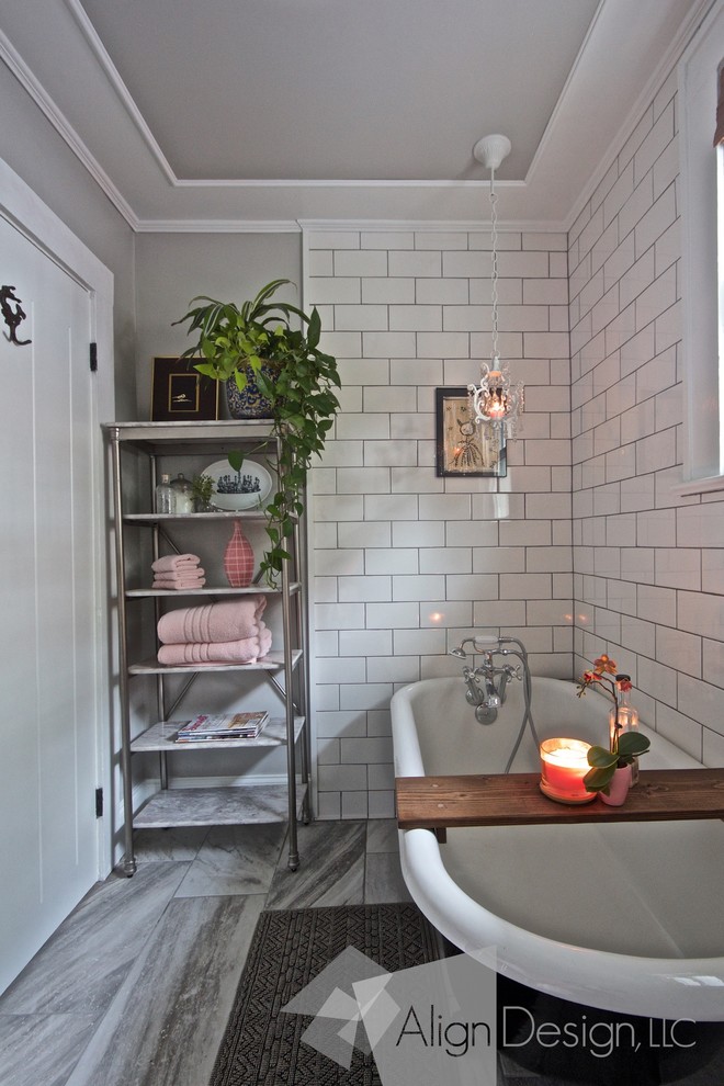 Idée de décoration pour une petite salle d'eau bohème avec des portes de placard noires, une baignoire sur pieds, un combiné douche/baignoire, WC à poser, un carrelage blanc, des carreaux de céramique, un mur gris, un sol en carrelage de porcelaine et une vasque.