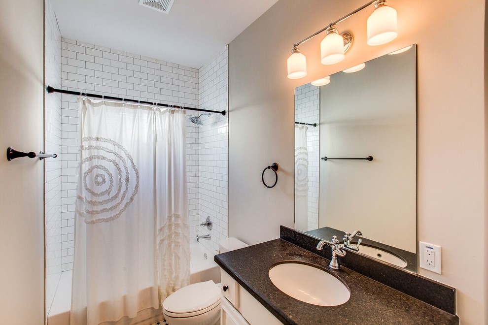 Photo of a medium sized victorian shower room bathroom in Houston with recessed-panel cabinets, white cabinets, an alcove bath, a shower/bath combination, white tiles, metro tiles, a submerged sink, granite worktops, a one-piece toilet, grey walls, mosaic tile flooring, white floors and a shower curtain.