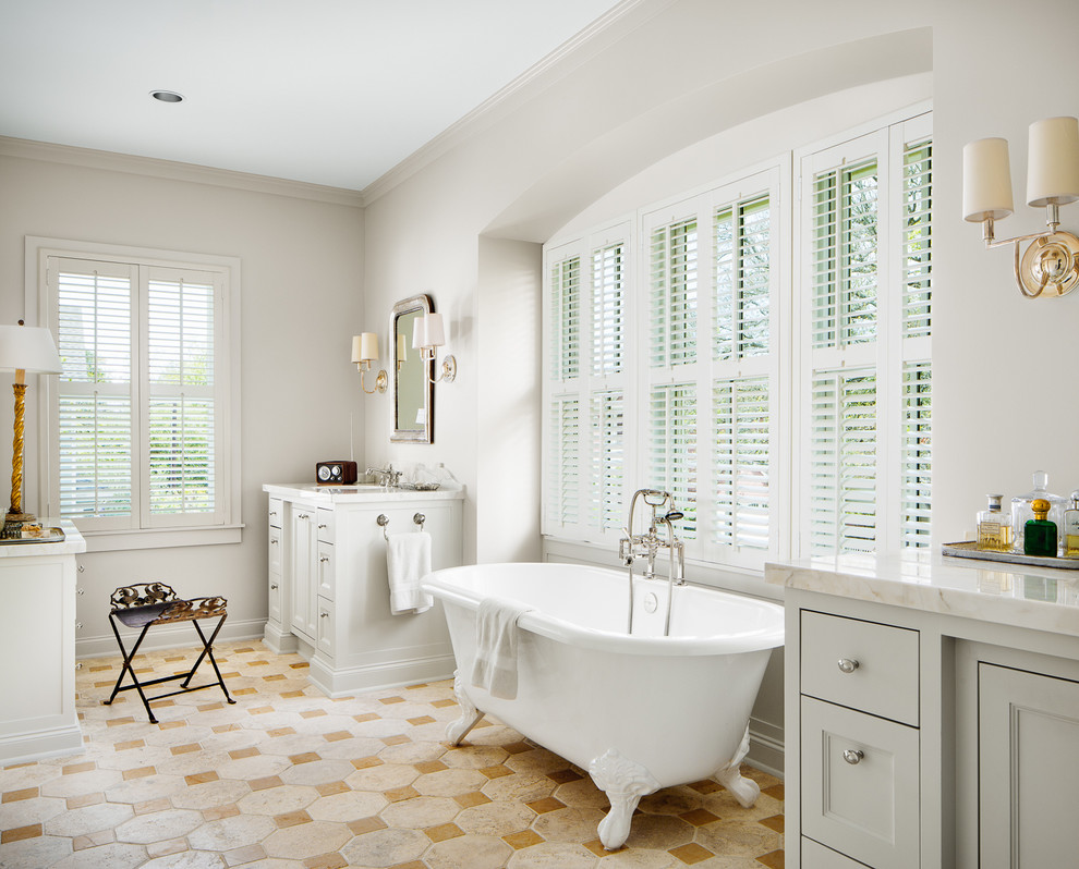 На фото: ванная комната в классическом стиле с врезной раковиной, фасадами с утопленной филенкой, серыми фасадами и ванной на ножках с
