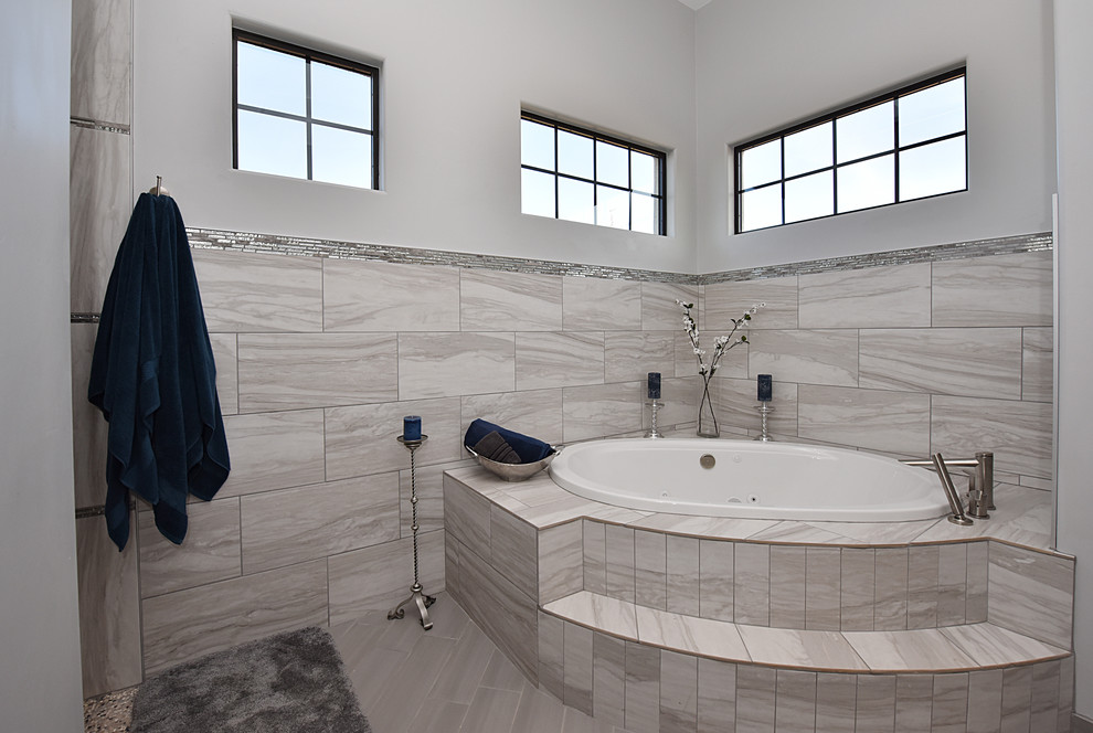 Idée de décoration pour une salle de bain principale design en bois foncé de taille moyenne avec un placard avec porte à panneau surélevé, une baignoire posée, un mur beige et un lavabo encastré.