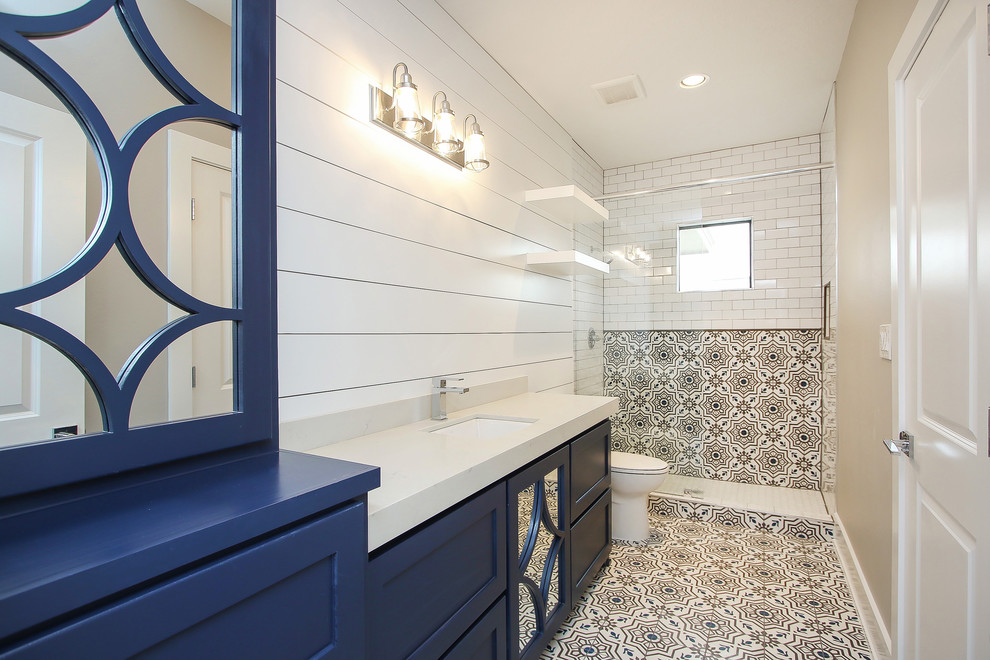 Ejemplo de cuarto de baño tradicional renovado con armarios tipo vitrina, puertas de armario azules, baldosas y/o azulejos de cemento, suelo de azulejos de cemento, ducha con puerta con bisagras y encimeras blancas