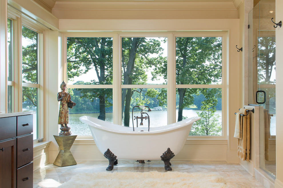 Immagine di una stanza da bagno etnica con ante in stile shaker, ante in legno bruno, vasca con piedi a zampa di leone, doccia alcova, piastrelle beige e pareti beige