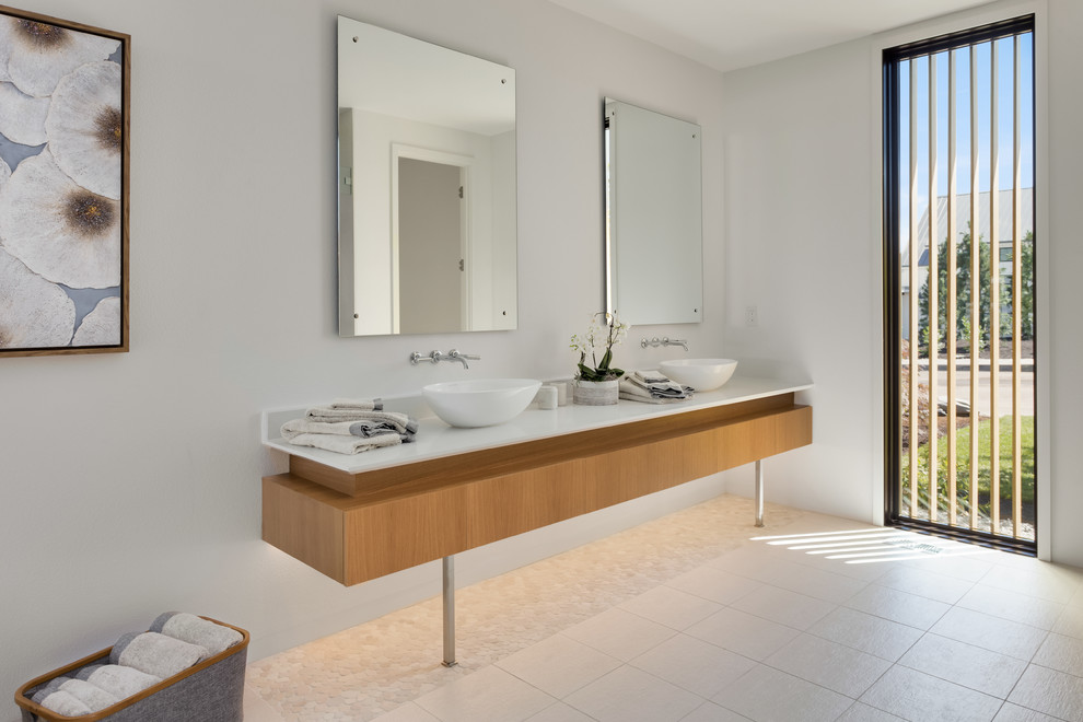 Cette image montre une grande salle de bain principale design en bois clair avec un mur blanc, une vasque, un sol beige, un carrelage blanc, un sol en carrelage de porcelaine et un plan de toilette en quartz.