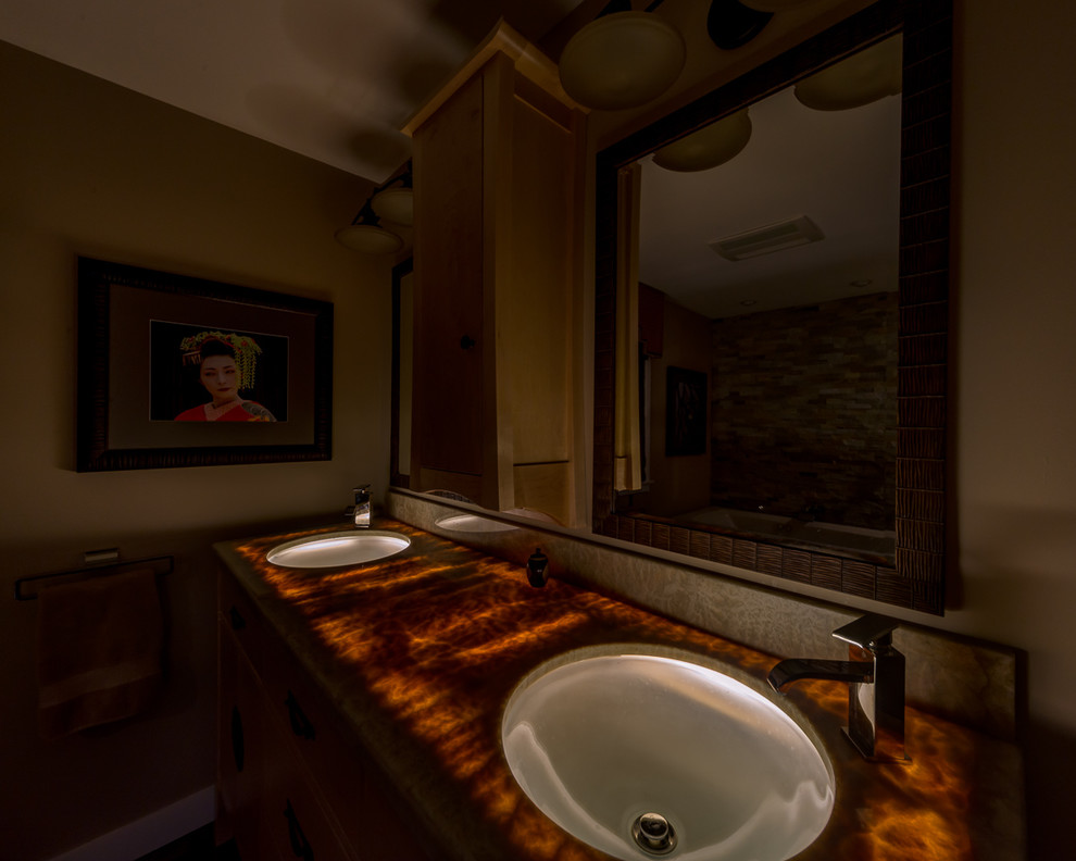 Foto di una stanza da bagno padronale etnica di medie dimensioni con consolle stile comò, ante in legno chiaro, piastrelle beige, piastrelle di ciottoli, parquet scuro, lavabo sottopiano e top in onice