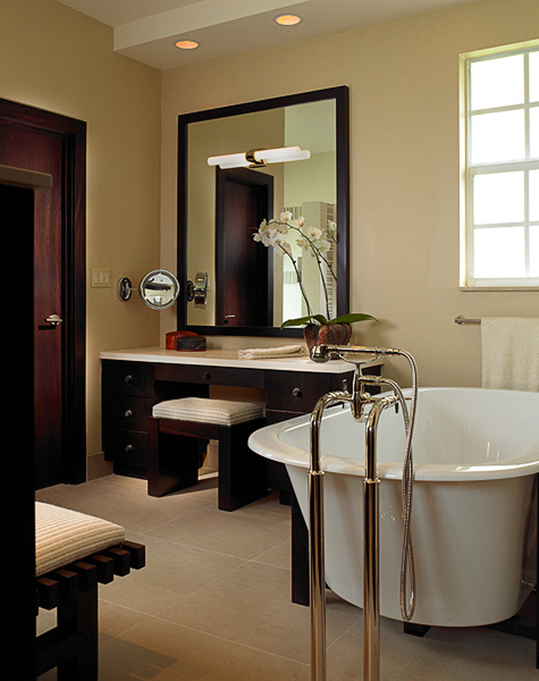 Inspiration for a large world-inspired ensuite bathroom in Miami with freestanding cabinets, dark wood cabinets, an alcove shower, beige walls, limestone flooring, onyx worktops and a freestanding bath.