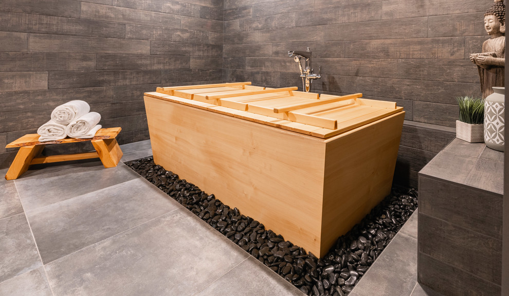 Пример оригинального дизайна: большая баня и сауна в восточном стиле с японской ванной, душевой комнатой, серой плиткой, керамогранитной плиткой, серыми стенами, полом из керамогранита, настольной раковиной, столешницей из дерева и серым полом
