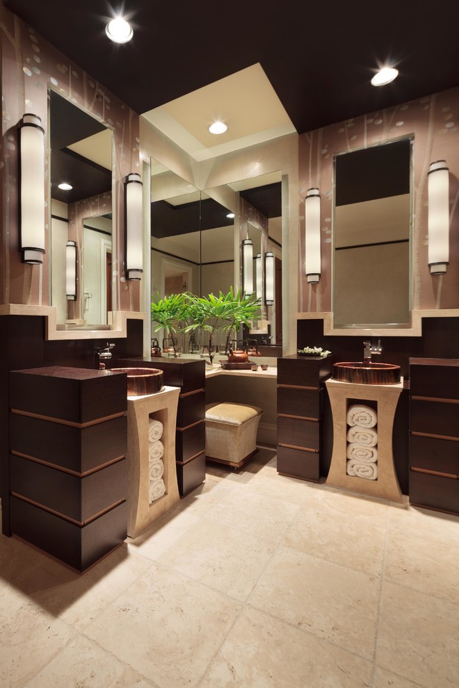 Cette photo montre une grande salle de bain principale asiatique avec un placard à porte plane, des portes de placard marrons, un mur marron, un sol en travertin, une vasque et un plan de toilette en bois.