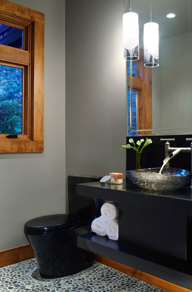 Bild på ett funkis svart svart badrum med dusch, med släta luckor, bruna skåp, en dusch i en alkov, ett urinoar, grå väggar, klinkergolv i keramik, ett fristående handfat, granitbänkskiva, flerfärgat golv och dusch med gångjärnsdörr