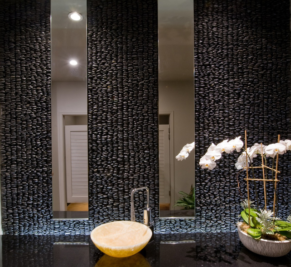 Стильный дизайн: ванная комната в современном стиле с настольной раковиной, мраморной столешницей, черной плиткой, галечной плиткой и бетонным полом - последний тренд