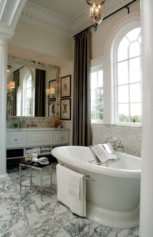 This is an example of a large traditional ensuite bathroom in Houston with raised-panel cabinets, white cabinets, marble worktops, a freestanding bath, grey tiles, mosaic tiles and marble flooring.