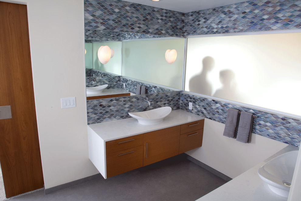 На фото: большая главная ванная комната в современном стиле с настольной раковиной, плоскими фасадами, светлыми деревянными фасадами, столешницей из искусственного кварца, синей плиткой, плиткой мозаикой и полом из керамогранита с