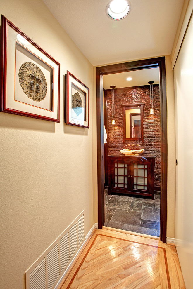 Foto di una piccola stanza da bagno padronale etnica con lavabo a bacinella, ante di vetro, ante in legno scuro e pavimento in ardesia