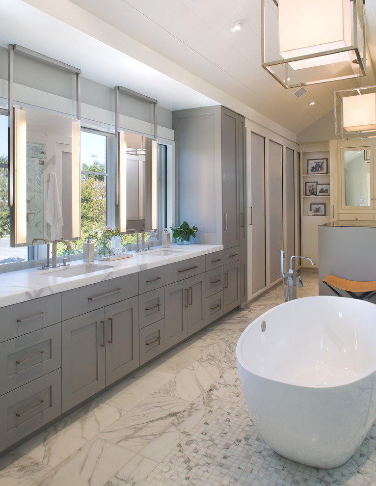 Идея дизайна: большая главная ванная комната в стиле неоклассика (современная классика) с врезной раковиной, фасадами в стиле шейкер, серыми фасадами, мраморной столешницей, отдельно стоящей ванной и мраморным полом