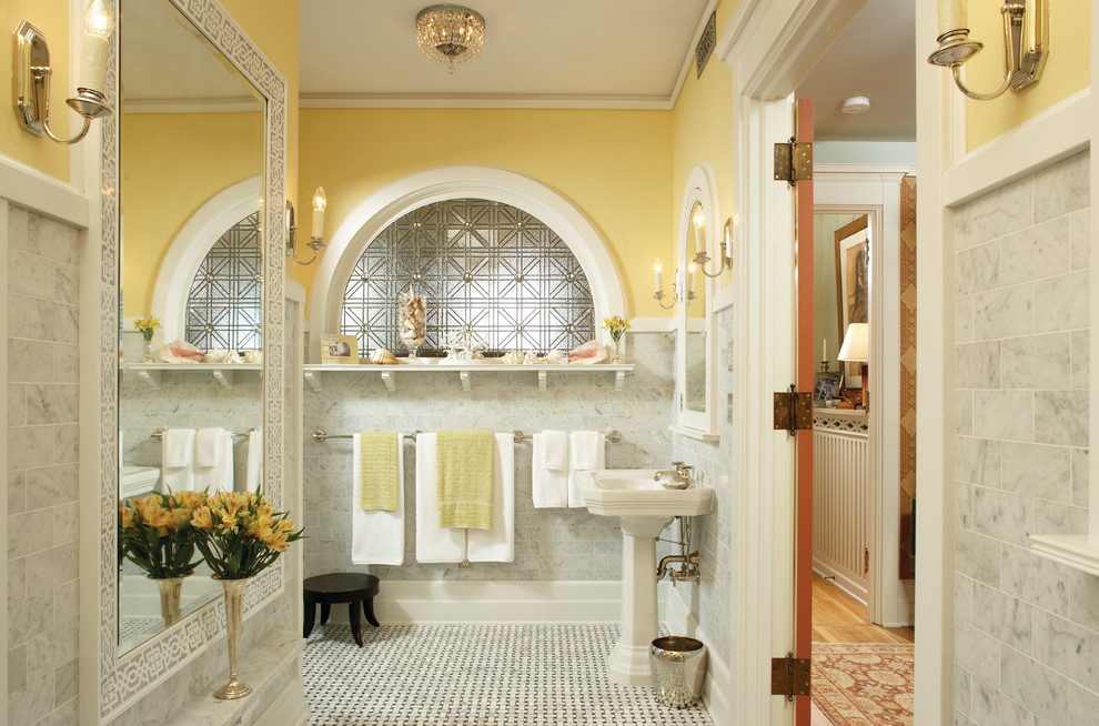 Стильный дизайн: главная ванная комната в классическом стиле с раковиной с пьедесталом, серой плиткой, каменной плиткой, желтыми стенами и мраморным полом - последний тренд