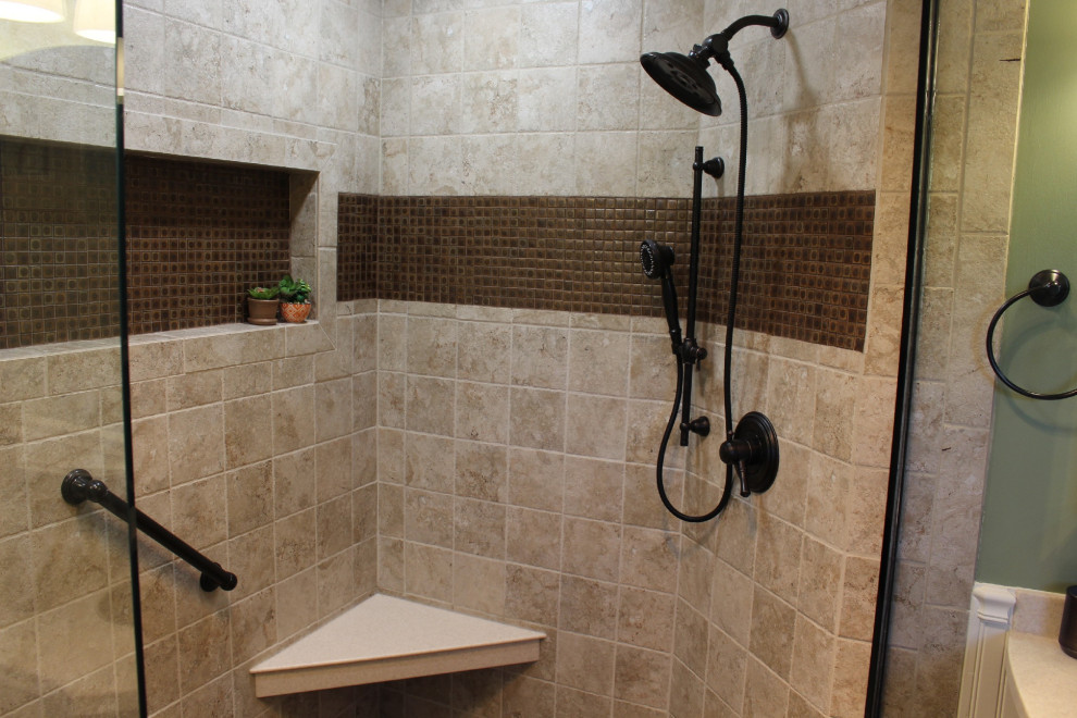 Photo of a large mediterranean ensuite bathroom in Indianapolis with freestanding cabinets, medium wood cabinets, a corner shower, a two-piece toilet, green walls, porcelain flooring, a submerged sink, solid surface worktops, beige floors, an open shower and beige worktops.