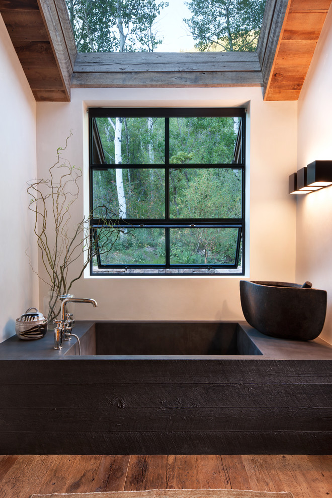 Cette image montre une salle de bain chalet avec un mur blanc, parquet foncé et un sol marron.