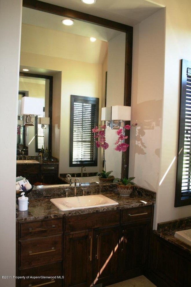 Foto di una stanza da bagno padronale chic di medie dimensioni con ante con bugna sagomata, ante in legno bruno, top in granito, vasca ad alcova e pareti beige