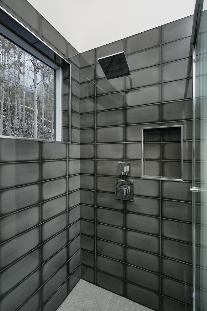 Immagine di una stanza da bagno design di medie dimensioni con doccia a filo pavimento, piastrelle grigie, piastrelle di vetro e porta doccia a battente