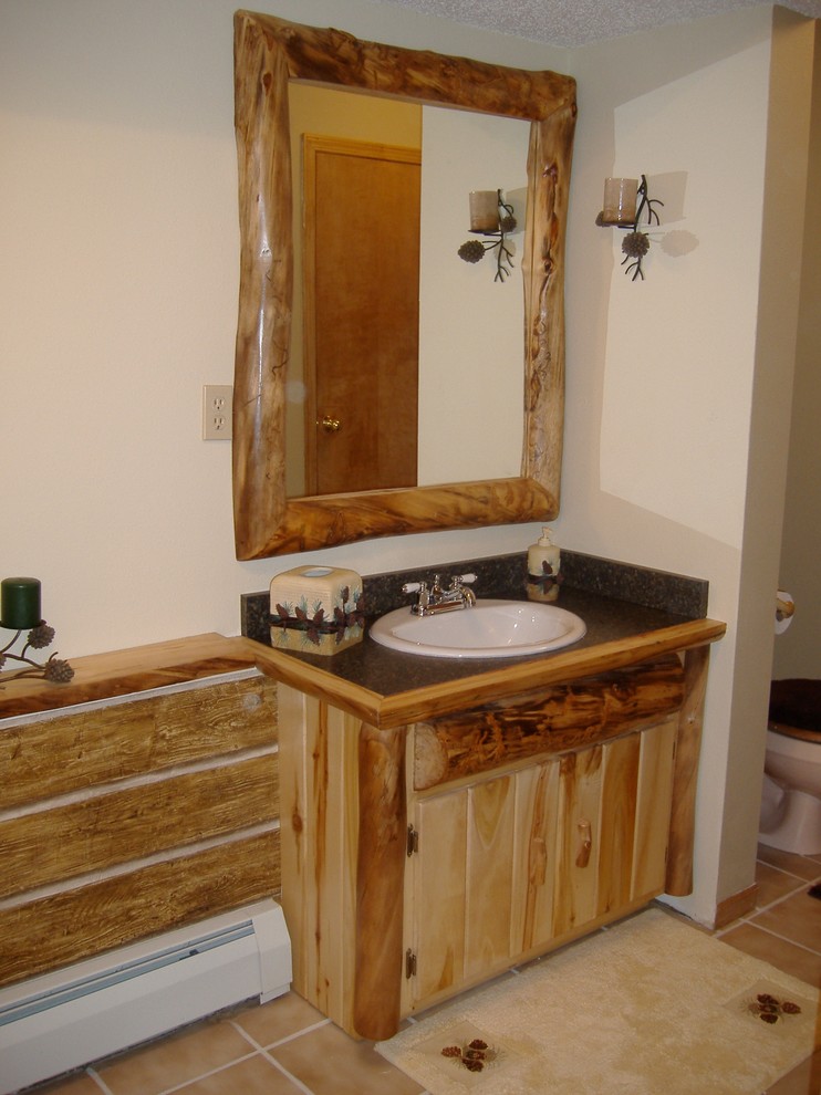 Réalisation d'une salle d'eau chalet en bois clair de taille moyenne avec un placard à porte plane, un mur blanc, un sol en carrelage de céramique, un lavabo posé, un plan de toilette en stratifié, un sol beige et un plan de toilette marron.