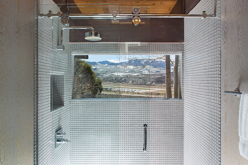 This is an example of a medium sized modern ensuite bathroom in Denver with a submerged sink, flat-panel cabinets, white cabinets, grey tiles and grey walls.
