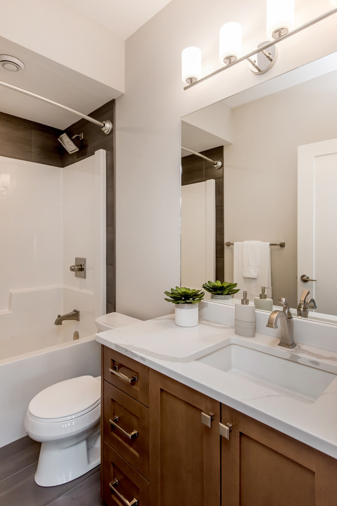 Idéer för ett mellanstort klassiskt vit badrum, med skåp i shakerstil, skåp i mellenmörkt trä, en dusch/badkar-kombination, grå kakel, keramikplattor, beige väggar, klinkergolv i keramik, ett undermonterad handfat, bänkskiva i kvartsit och grått golv