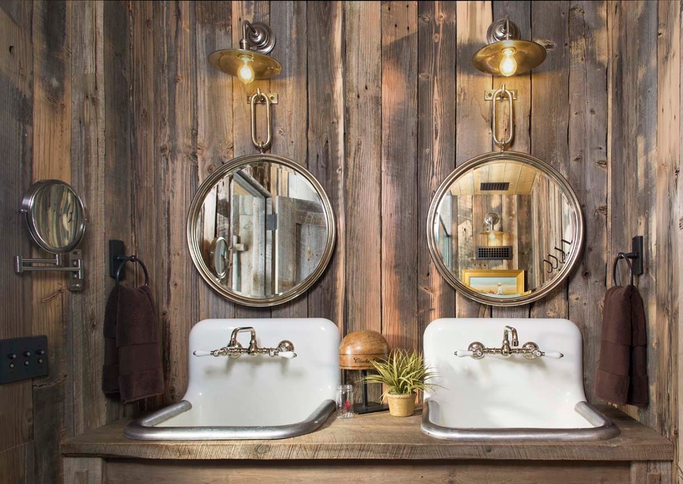 Cette image montre une petite salle de bain chalet avec un lavabo posé, un plan de toilette en bois, un mur marron et un plan de toilette marron.