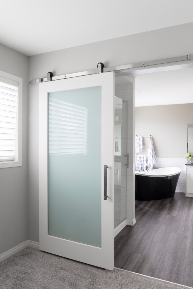 Inspiration for a large traditional ensuite bathroom in Calgary with shaker cabinets, white cabinets, a freestanding bath, an alcove shower, a one-piece toilet, white tiles, ceramic tiles, grey walls, vinyl flooring, a submerged sink, engineered stone worktops, brown floors, a hinged door and grey worktops.