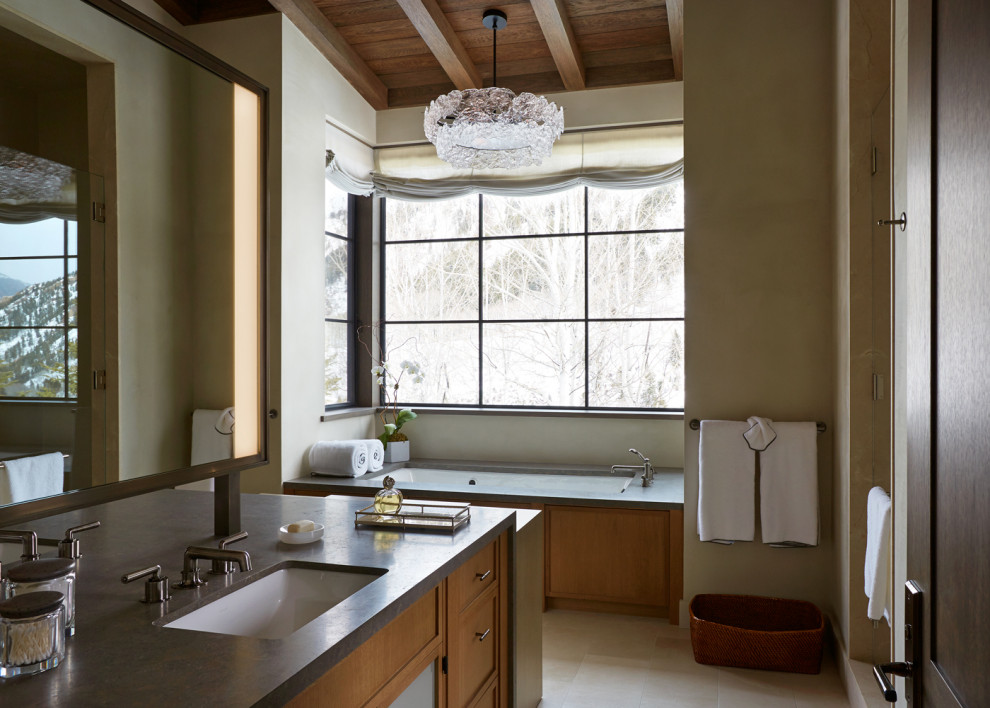 Idées déco pour une salle de bain principale montagne en bois brun avec un placard avec porte à panneau encastré, un mur beige, un lavabo encastré, un sol beige, un plan de toilette gris, meuble-lavabo encastré, poutres apparentes, un plafond voûté et un plafond en bois.