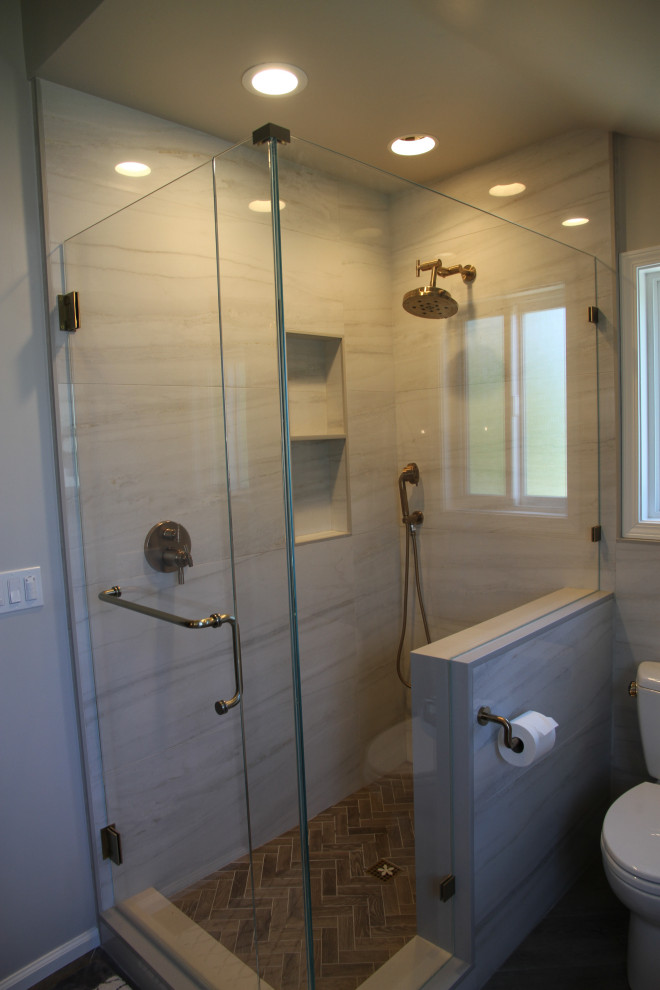 Bild på ett mellanstort funkis grå grått en-suite badrum, med skåp i shakerstil, blå skåp, ett fristående badkar, en toalettstol med hel cisternkåpa, porslinskakel, klinkergolv i porslin, ett undermonterad handfat, bänkskiva i kvarts, grått golv, en hörndusch, grå kakel, grå väggar och dusch med gångjärnsdörr