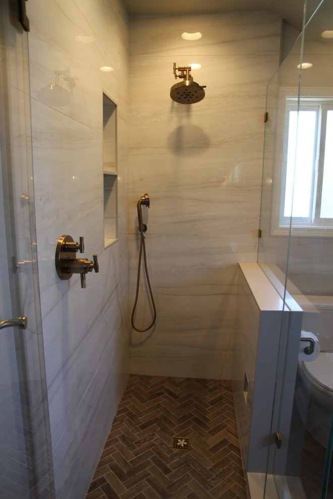 Réalisation d'une salle de bain principale design de taille moyenne avec un placard à porte shaker, des portes de placard bleues, une baignoire indépendante, WC à poser, des carreaux de porcelaine, un sol en carrelage de porcelaine, un lavabo encastré, un plan de toilette en quartz modifié, un sol gris, un plan de toilette gris, une niche, meuble double vasque, meuble-lavabo encastré, une douche d'angle, un carrelage gris, un mur gris et une cabine de douche à porte battante.