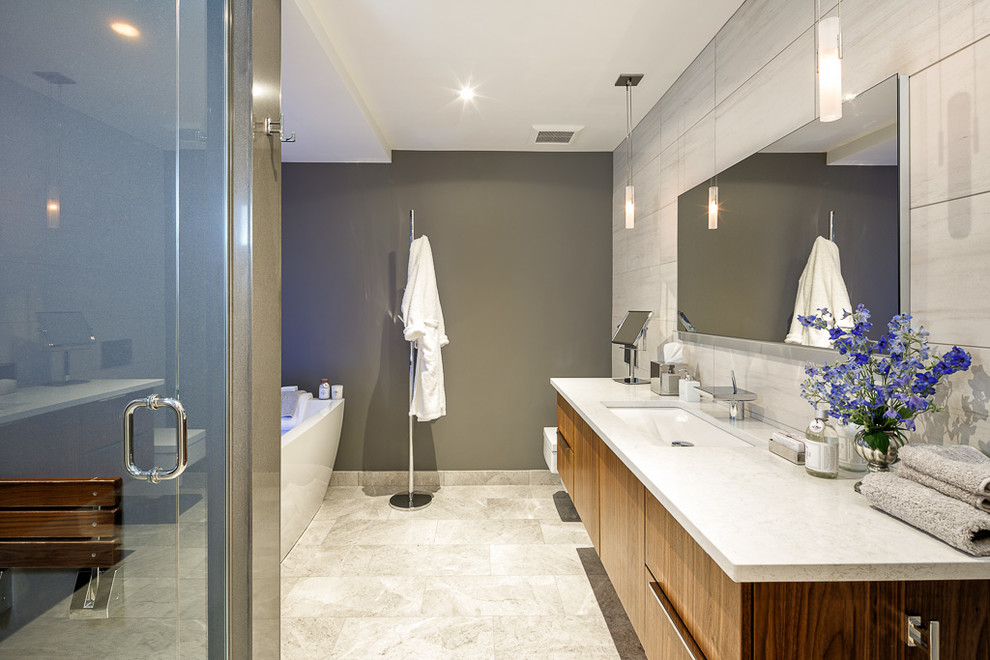 Exemple d'une salle de bain principale tendance en bois brun de taille moyenne avec un lavabo encastré, un placard à porte plane, un plan de toilette en marbre, une baignoire indépendante, un carrelage beige, un mur blanc, un sol en marbre et WC suspendus.