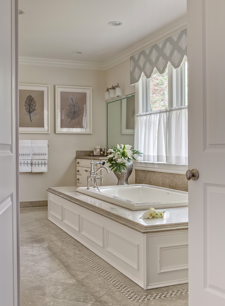 На фото: большая главная ванная комната в классическом стиле с белыми фасадами, накладной ванной, бежевыми стенами, полом из керамической плитки и серым полом