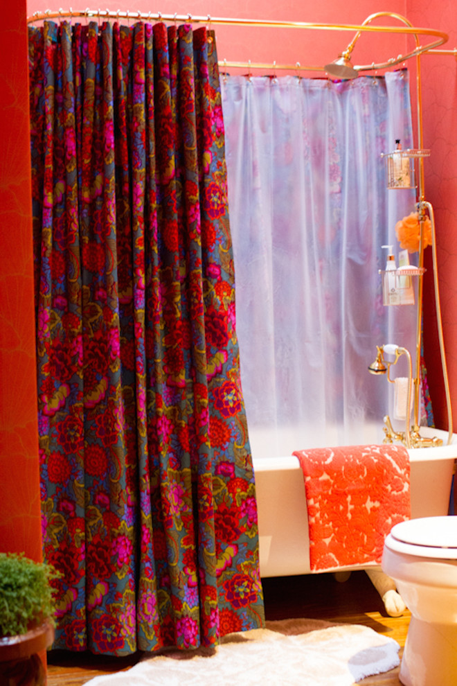 Idee per una stanza da bagno bohémian di medie dimensioni con vasca con piedi a zampa di leone, vasca/doccia, pareti rosse, parquet scuro, pavimento marrone e doccia con tenda