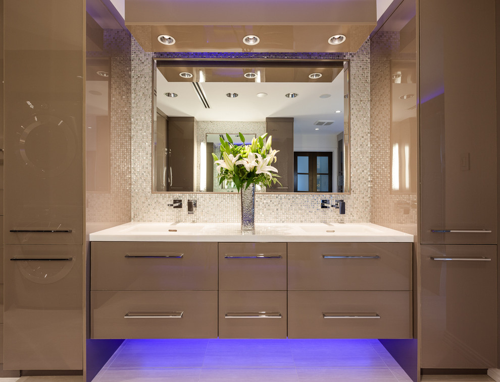 Imagen de cuarto de baño principal actual con lavabo integrado, armarios con paneles lisos, puertas de armario marrones y baldosas y/o azulejos en mosaico