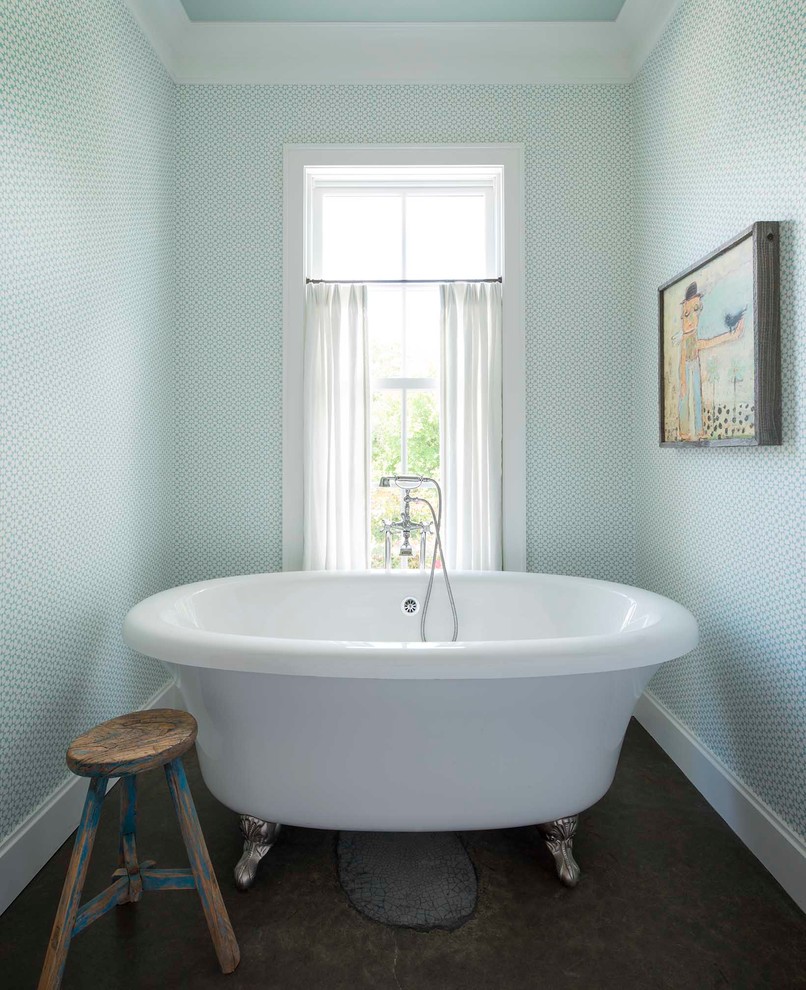 Réalisation d'une salle de bain champêtre avec une baignoire sur pieds et un mur bleu.