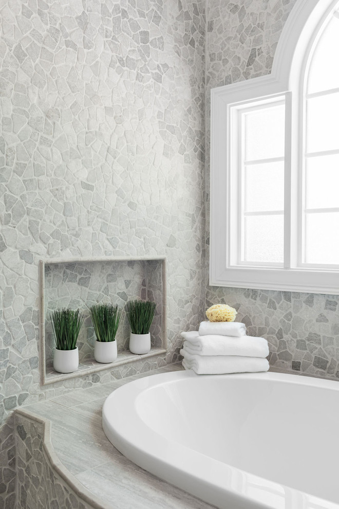 Immagine di una stanza da bagno padronale tradizionale di medie dimensioni con vasca da incasso, piastrelle grigie e piastrelle in pietra