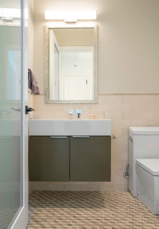 Ispirazione per un'ampia stanza da bagno minimal con lavabo integrato, ante marroni, WC monopezzo, piastrelle beige, piastrelle in gres porcellanato, pareti grigie e pavimento in pietra calcarea
