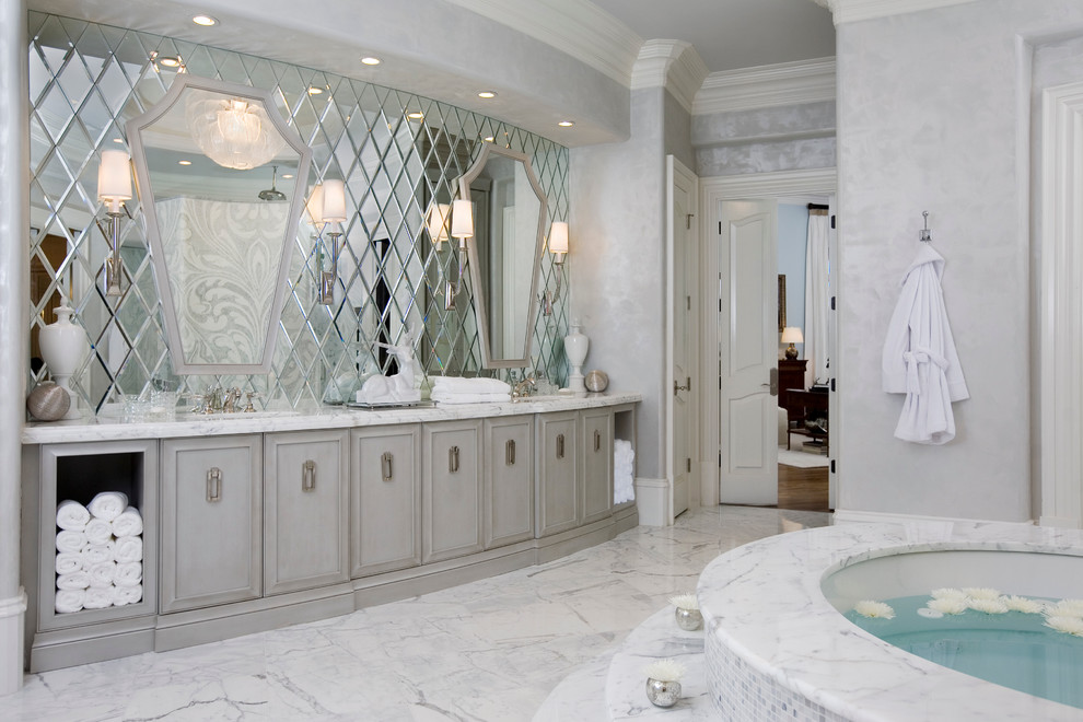 Foto di una stanza da bagno design con ante grigie, vasca sottopiano e piastrelle bianche