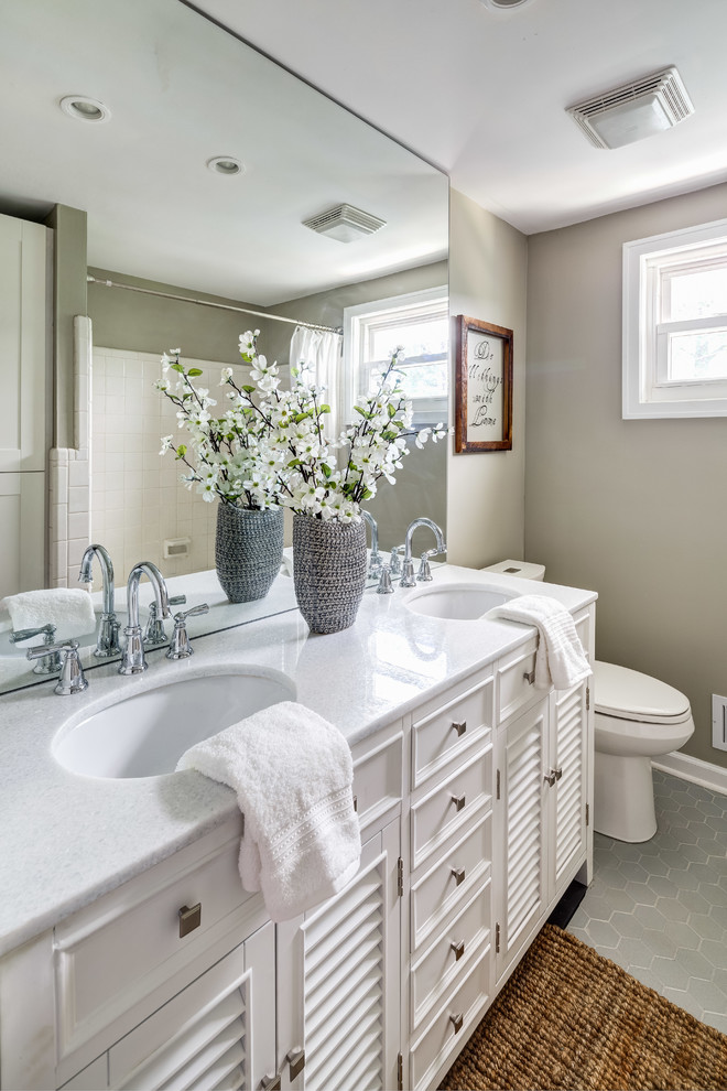 Modelo de cuarto de baño principal clásico pequeño con puertas de armario blancas, bañera encastrada, combinación de ducha y bañera, paredes beige, suelo gris, ducha con cortina y encimeras blancas