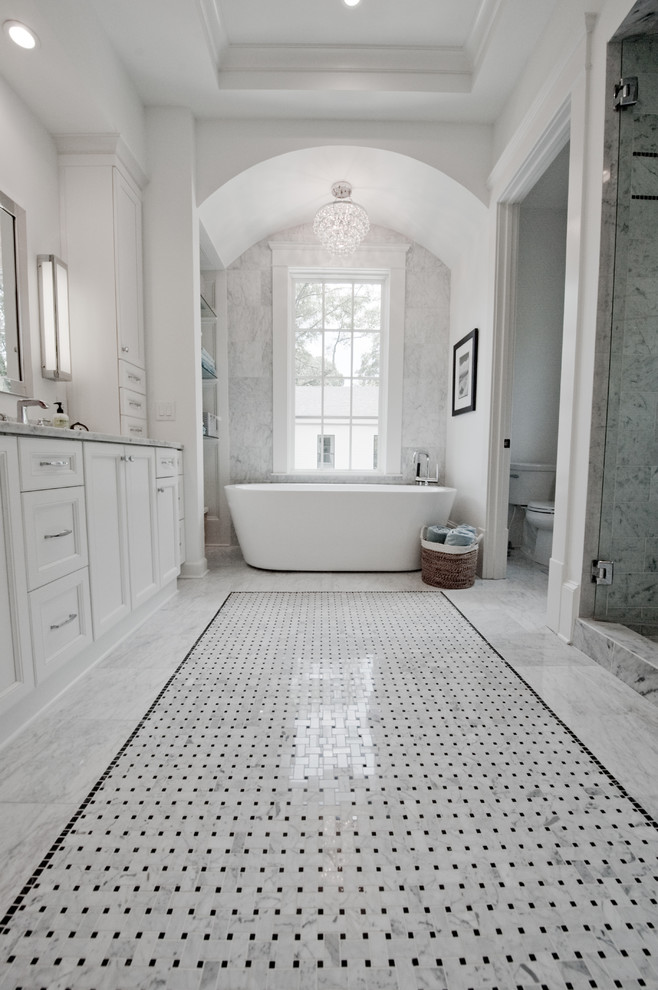 Inspiration för stora klassiska en-suite badrum, med skåp i shakerstil, vita skåp, marmorbänkskiva, grå kakel, ett fristående badkar, en toalettstol med separat cisternkåpa, ett undermonterad handfat, vita väggar, marmorgolv, en dusch i en alkov, stenkakel, grått golv och dusch med gångjärnsdörr