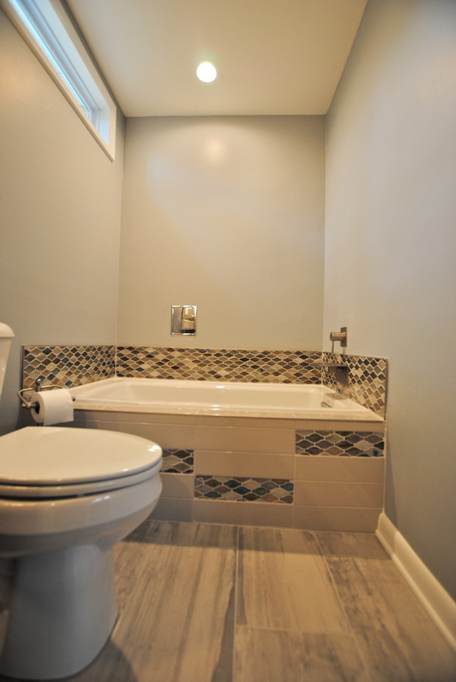 Foto di una stanza da bagno moderna di medie dimensioni con lavabo sottopiano, ante lisce, ante bianche, top in quarzite, vasca da incasso, vasca/doccia, piastrelle blu, piastrelle in gres porcellanato, pareti bianche e pavimento in gres porcellanato