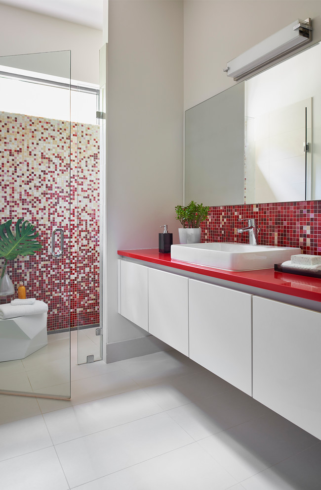 Inspiration for a medium sized contemporary shower room bathroom in Atlanta with flat-panel cabinets, white cabinets, a built-in shower, multi-coloured tiles, mosaic tiles, white walls, porcelain flooring, a vessel sink, engineered stone worktops, grey floors, a hinged door, a one-piece toilet and red worktops.