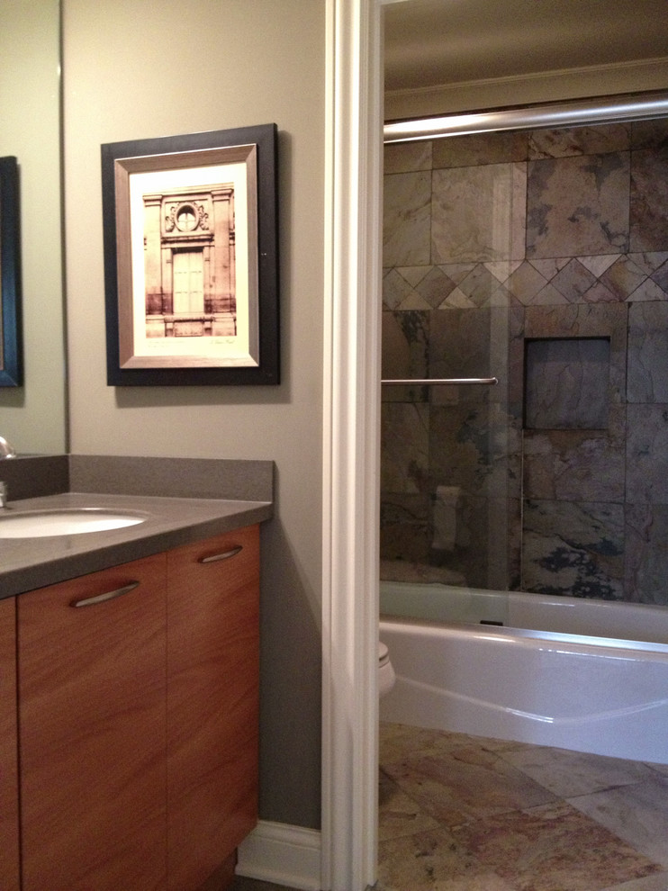 Esempio di una stanza da bagno tradizionale di medie dimensioni con lavabo sottopiano, ante lisce, ante in legno scuro, vasca ad alcova, vasca/doccia e WC monopezzo
