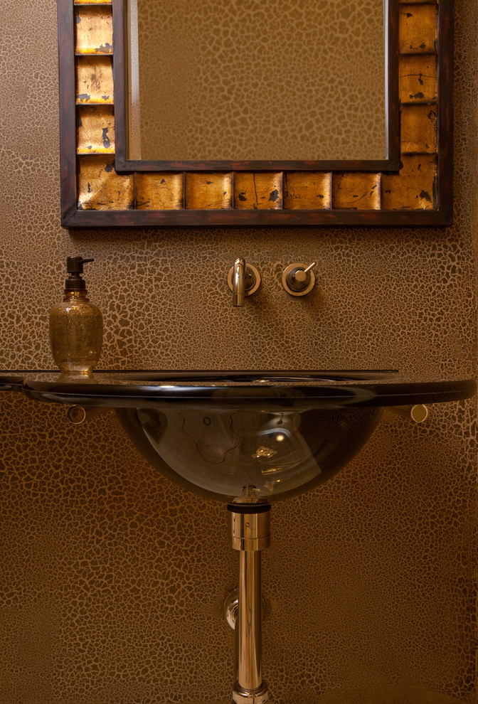 Diseño de cuarto de baño tradicional renovado de tamaño medio con lavabo suspendido, armarios con paneles lisos, puertas de armario de madera oscura, sanitario de una pieza, encimera de vidrio, paredes marrones y suelo de travertino