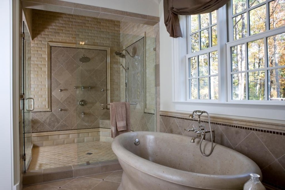 Cette photo montre une grande salle de bain principale tendance avec une baignoire indépendante, un espace douche bain, un carrelage beige, un carrelage de pierre, un mur beige, un sol en travertin, un sol beige et une cabine de douche à porte battante.