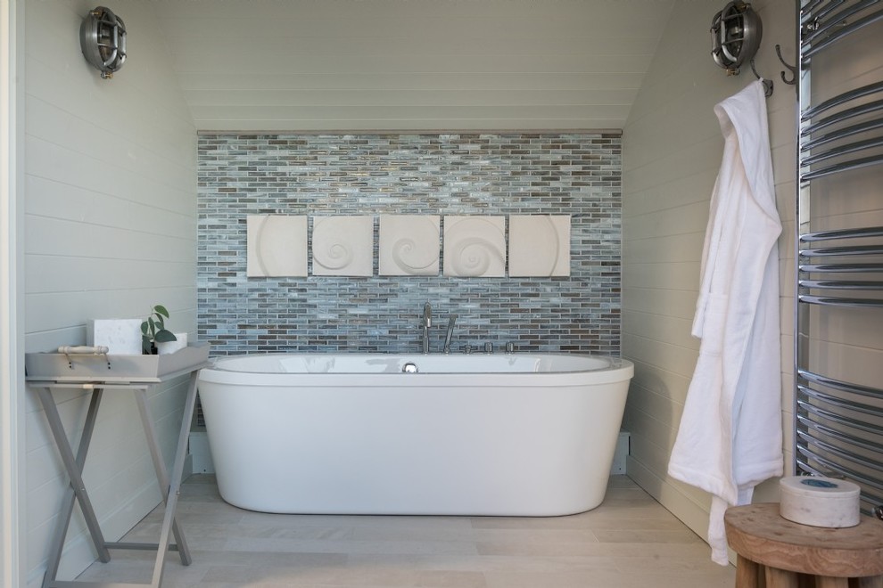 Inspiration för ett litet maritimt badrum, med ett fristående badkar, vita väggar och beiget golv