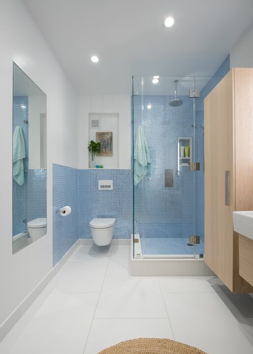 Стильный дизайн: ванная комната среднего размера в стиле неоклассика (современная классика) с плоскими фасадами, светлыми деревянными фасадами, синей плиткой, керамической плиткой, белыми стенами, полом из керамогранита, душевой кабиной, раковиной с несколькими смесителями, мраморной столешницей, белым полом, душем с распашными дверями, угловым душем и инсталляцией - последний тренд