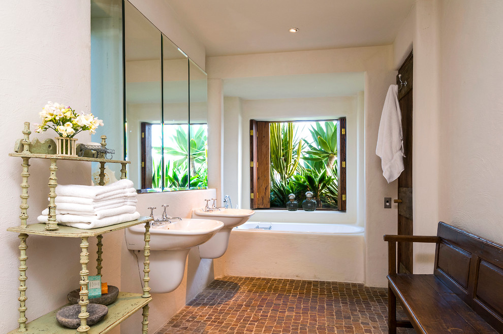 Exempel på ett eklektiskt badrum, med ett väggmonterat handfat, ett badkar i en alkov, vita väggar och tegelgolv