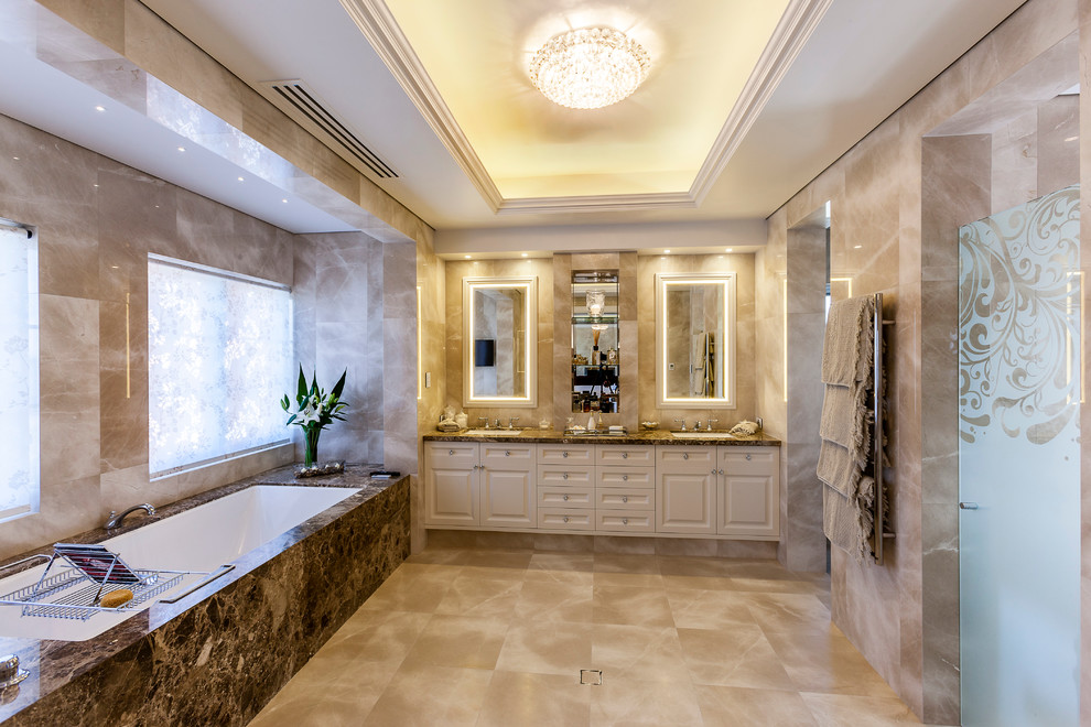 На фото: большая главная ванная комната в классическом стиле с фасадами в стиле шейкер, бежевыми фасадами, мраморной столешницей, врезной раковиной, полновстраиваемой ванной, душем в нише, бежевой плиткой и бежевыми стенами с